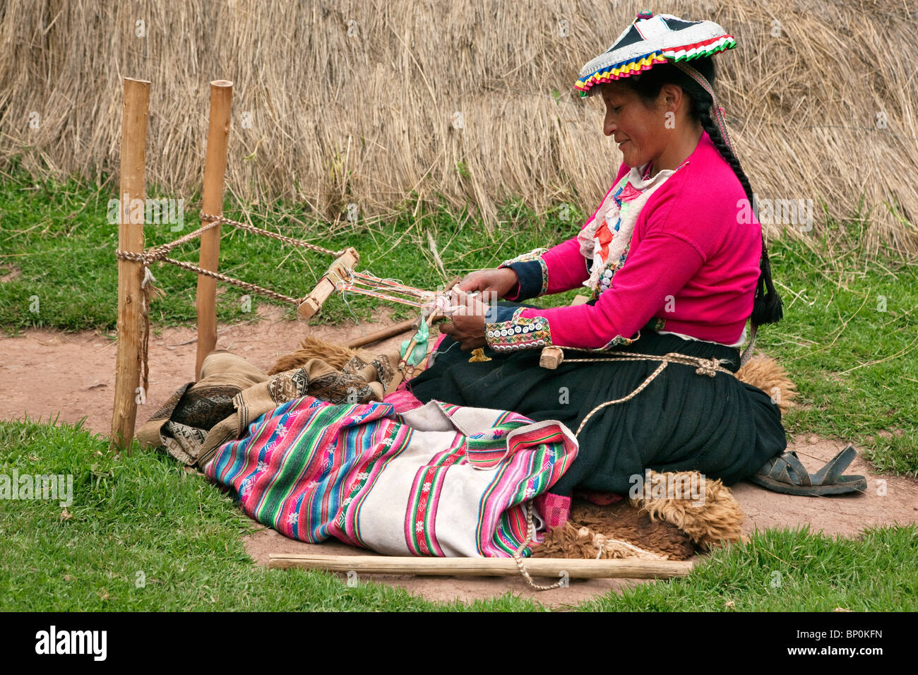 Peru. Eine indische Frau spinnt kleine Streifen von bunten Tuch auf ihre traditionellen hölzernen Webstuhl. Stockfoto