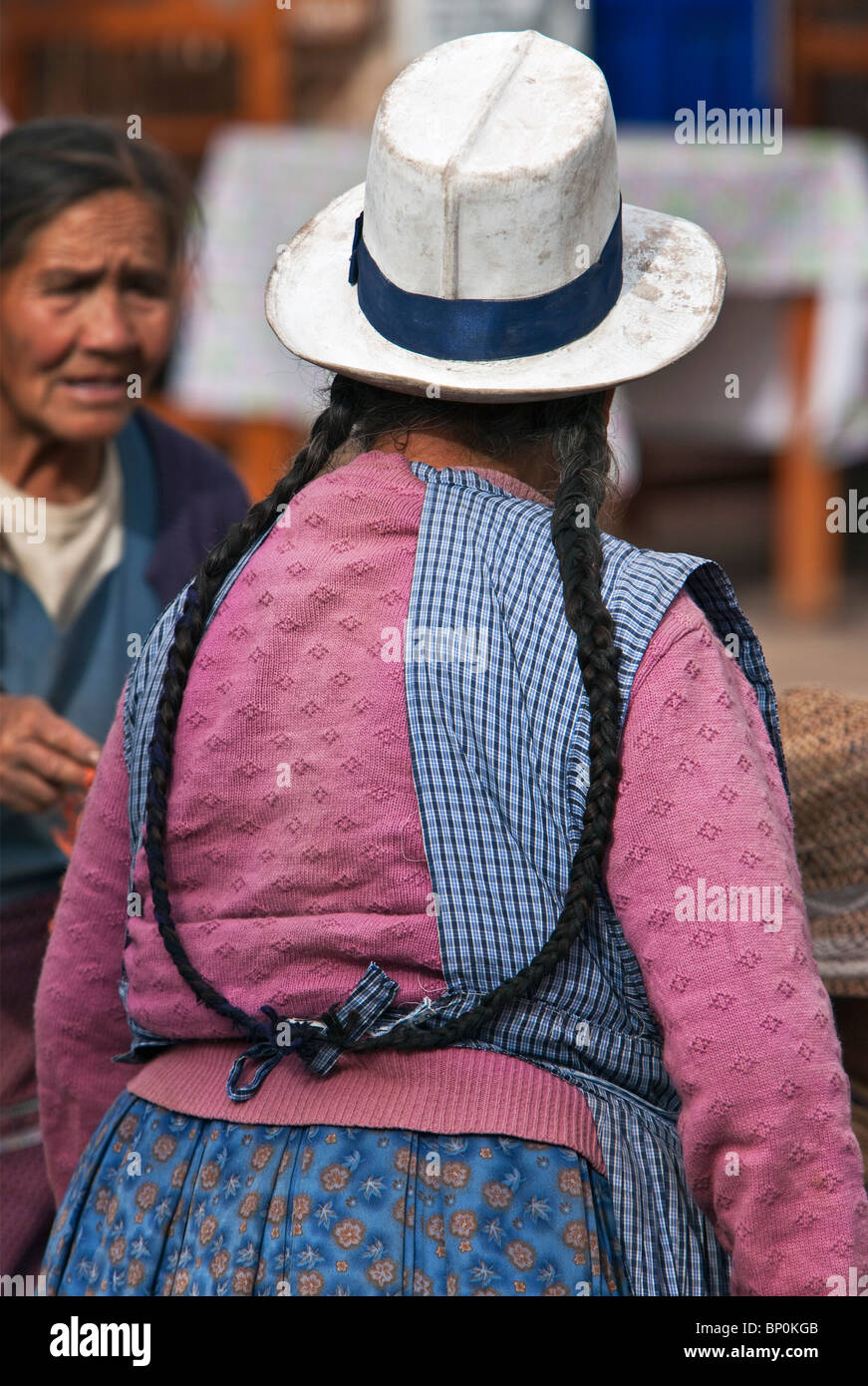 Peru. Eine Inderin mit langen Zöpfen in Pisacs belebten Sonntagsmarkt. Stockfoto