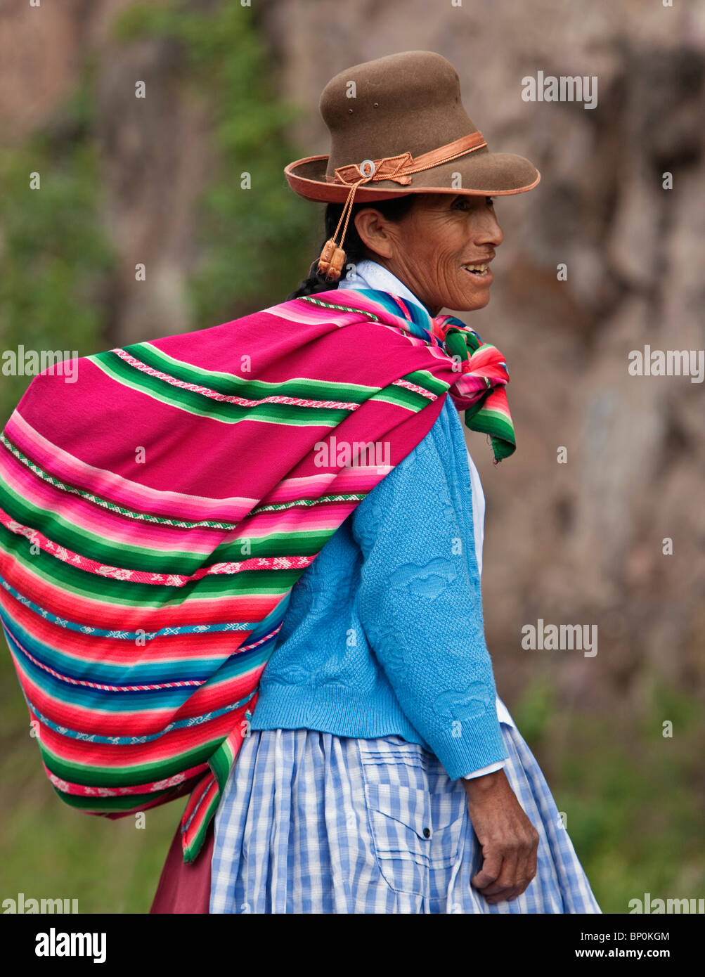 Peru. Eine indische Frau trägt einen Filzhut trägt ihre hofeigenen Produkte auf den Markt in einer bunten Decke. Stockfoto