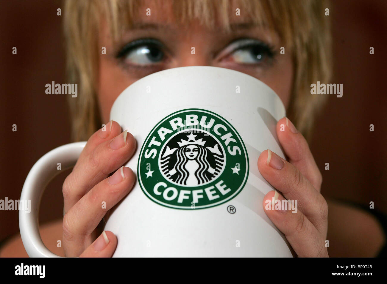 Hübsche Frau, einen Starbucks Kaffee trinken. Bild von James Boardman. Stockfoto