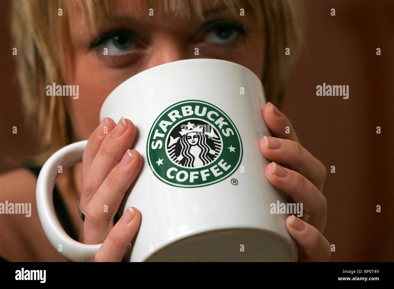Hübsche Frau, einen Starbucks Kaffee trinken. Bild von James Boardman. Stockfoto