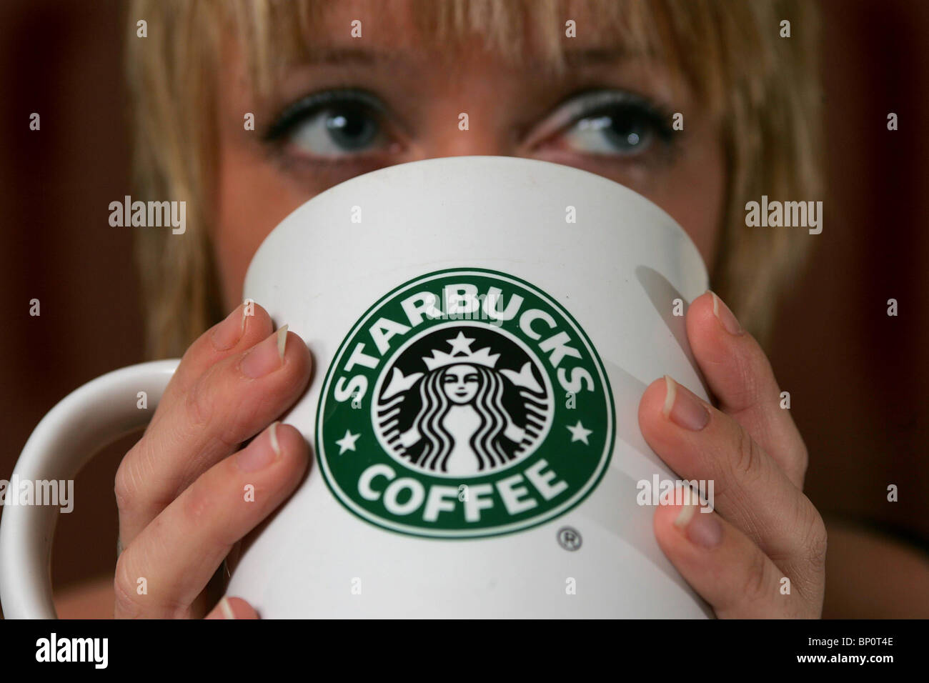 Hübsche Frau, einen Starbucks Kaffee trinken. Bild von James Boardman. Stockfoto