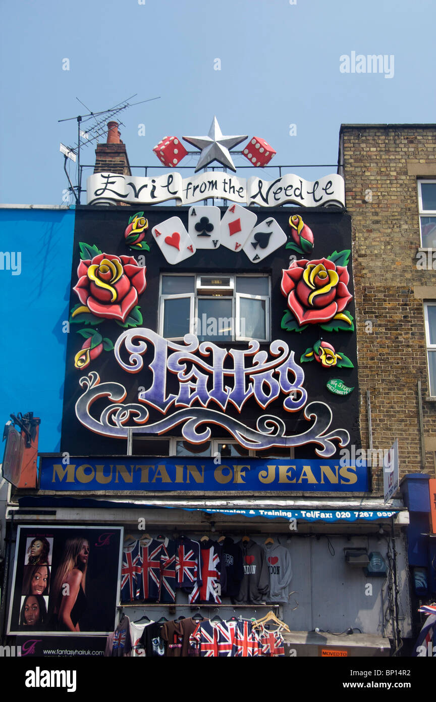 Ladenfront auf Camden High Street böse aus der Nadel, Berg von Jeans und Friseur North London England UK Stockfoto