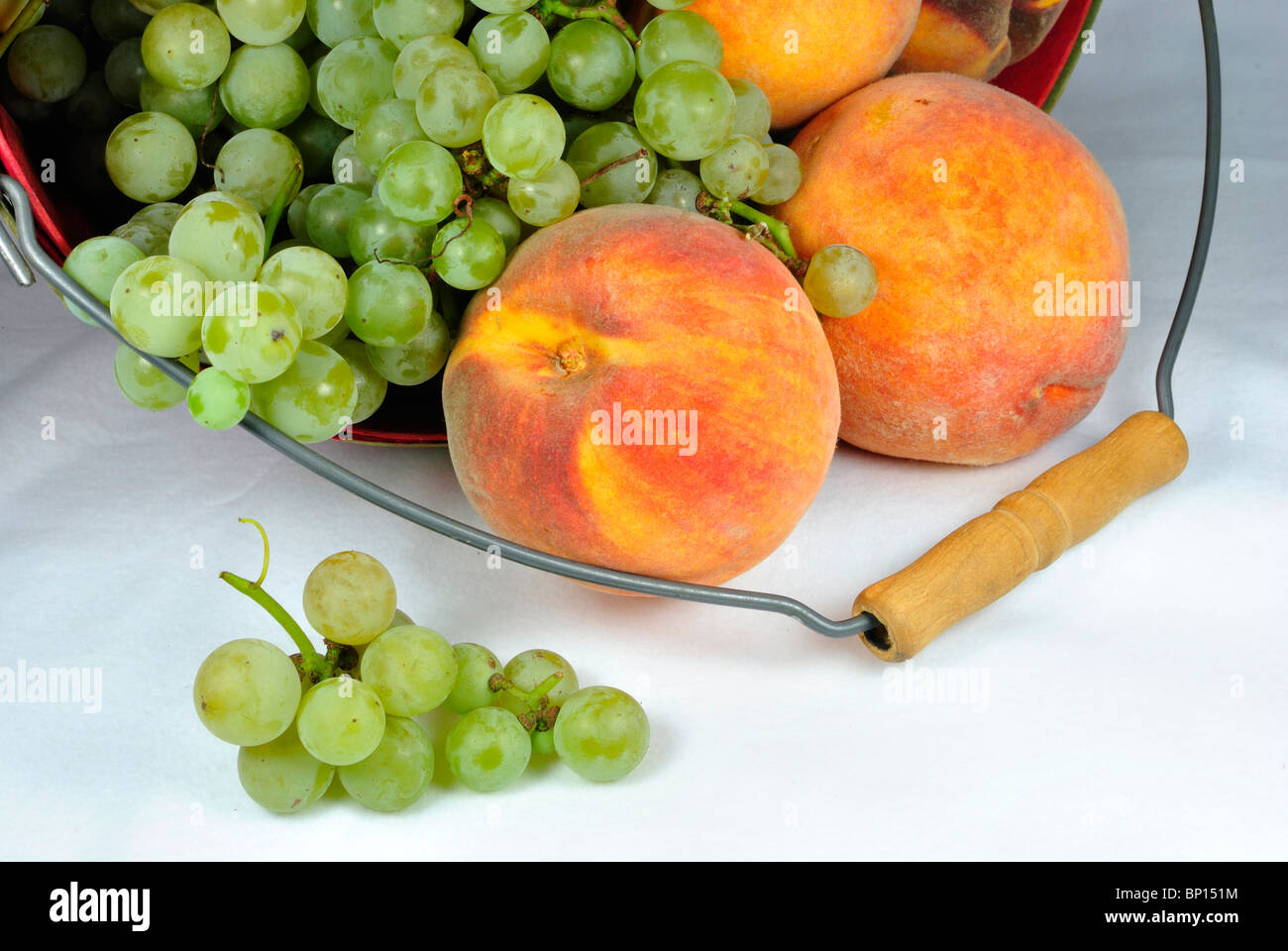 Obstkorb mit Trauben und Pfirsichen Stockfoto