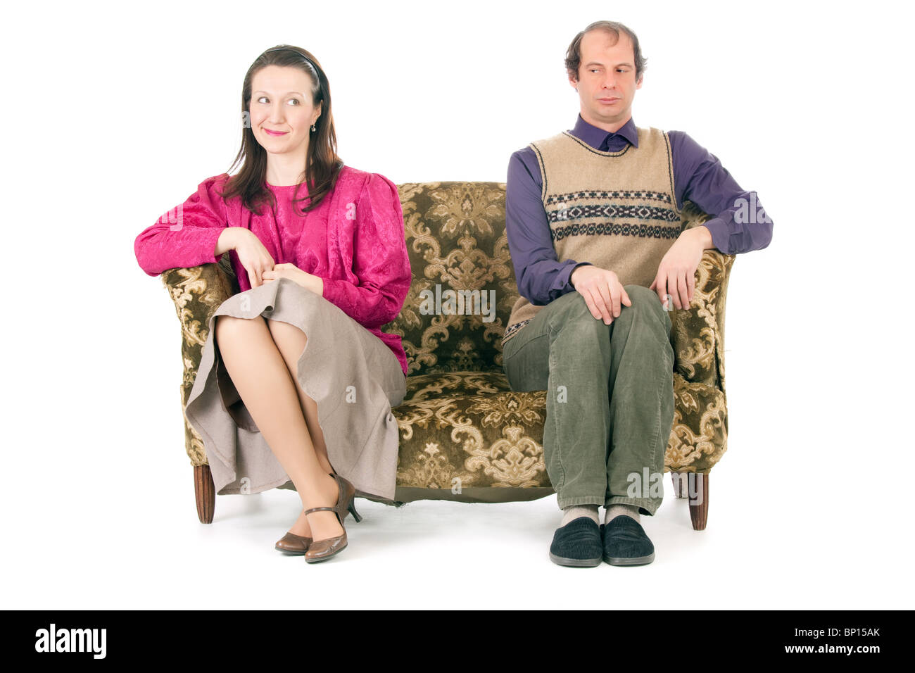 alt aussehende Paar beim Konflikt aufgewirbelt auf Vintage Couch isoliert auf weiss Stockfoto