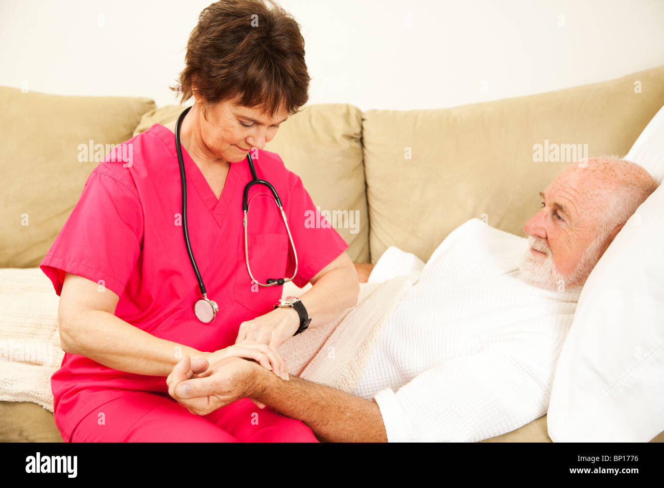 Home Gesundheit Krankenschwester am Puls eines älteren Patienten. Stockfoto