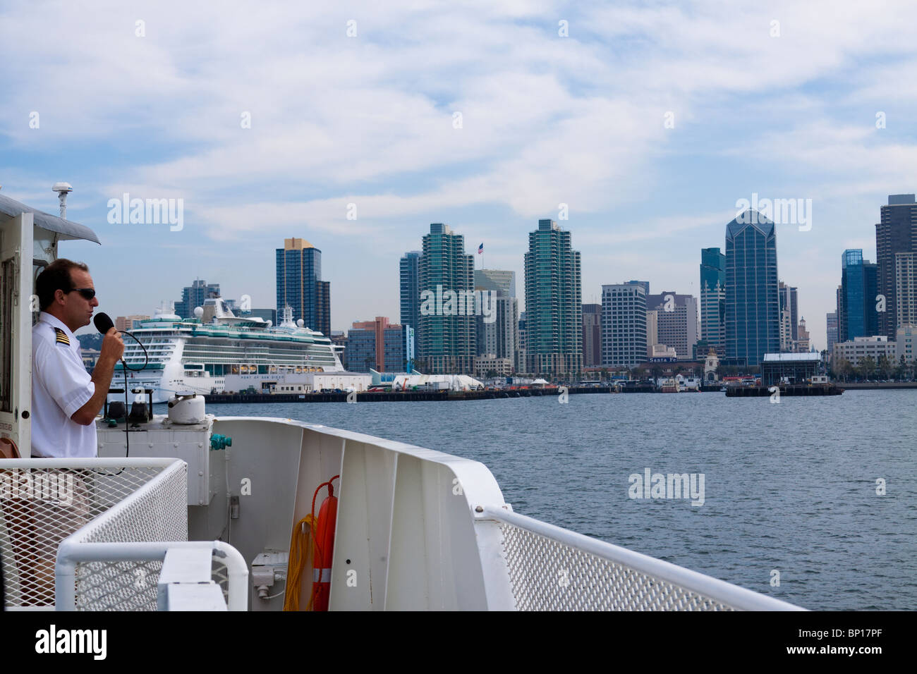 Boot-Tour-Guide beschreibt die Sehenswürdigkeiten in San Diego Bay mit der Skyline von San Diego im Blick Stockfoto