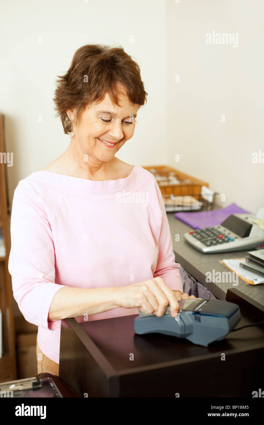 Verkäuferin läuft die Kreditkarte des Kunden durch das Terminal. Stockfoto