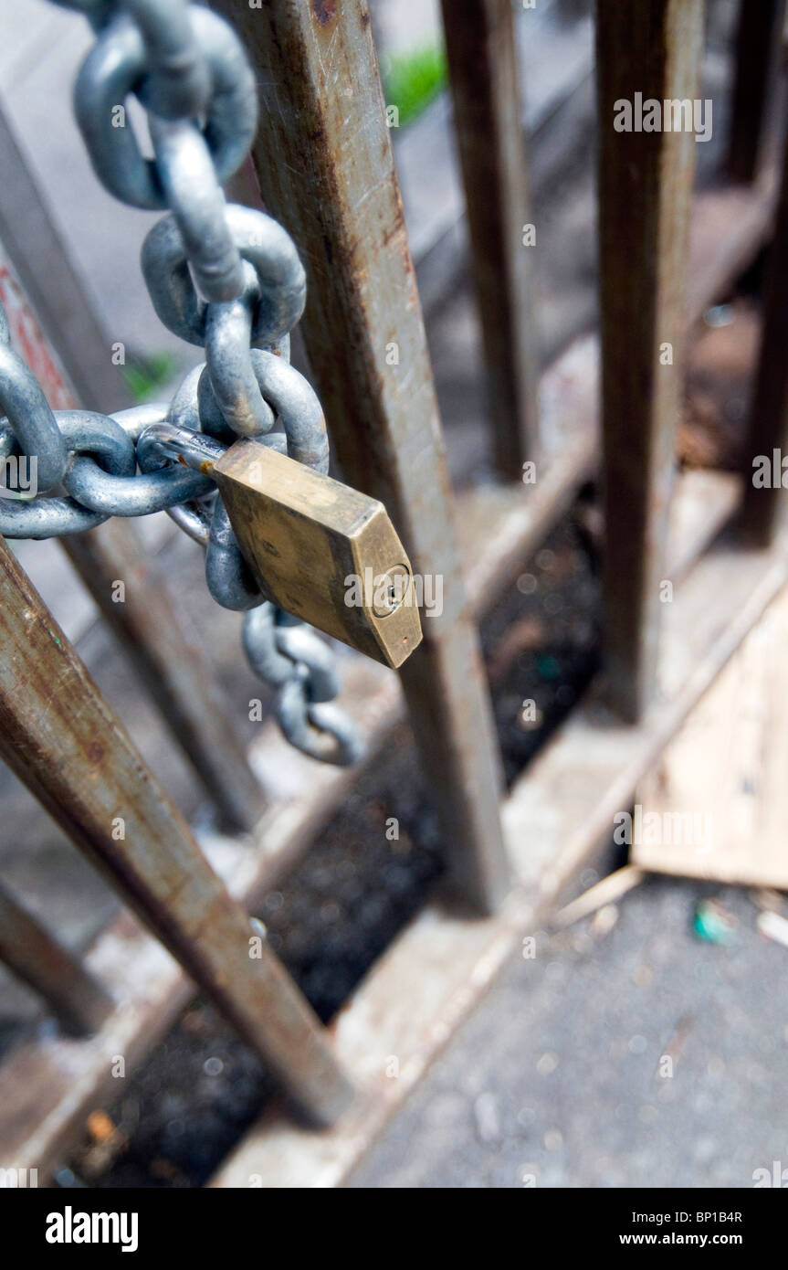 Vorhängeschloss und Kette sichern ein Metalltor Stockfoto