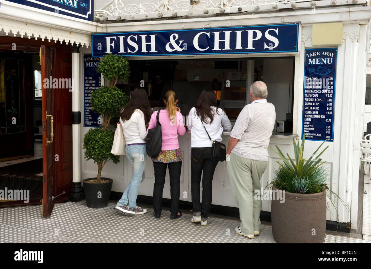 Eine Schlange von Menschen vor einem Fish and Chips Laden am Pier von Brighton Sussex UK Stockfoto