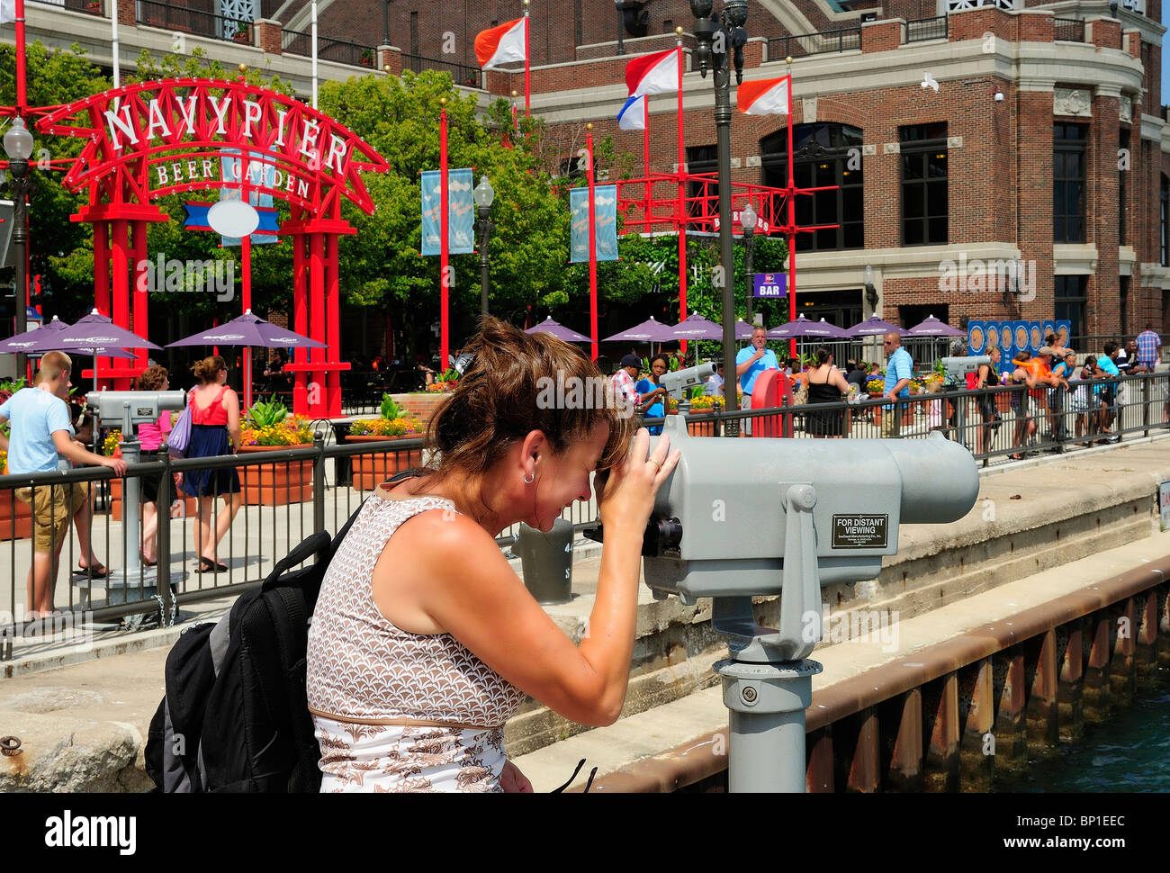 Blick auf Lake Michigan durch Pay-Teleskop am Navy Pier Chicago Frau. Beer Garden & Ausstellungshalle im Hintergrund. Stockfoto