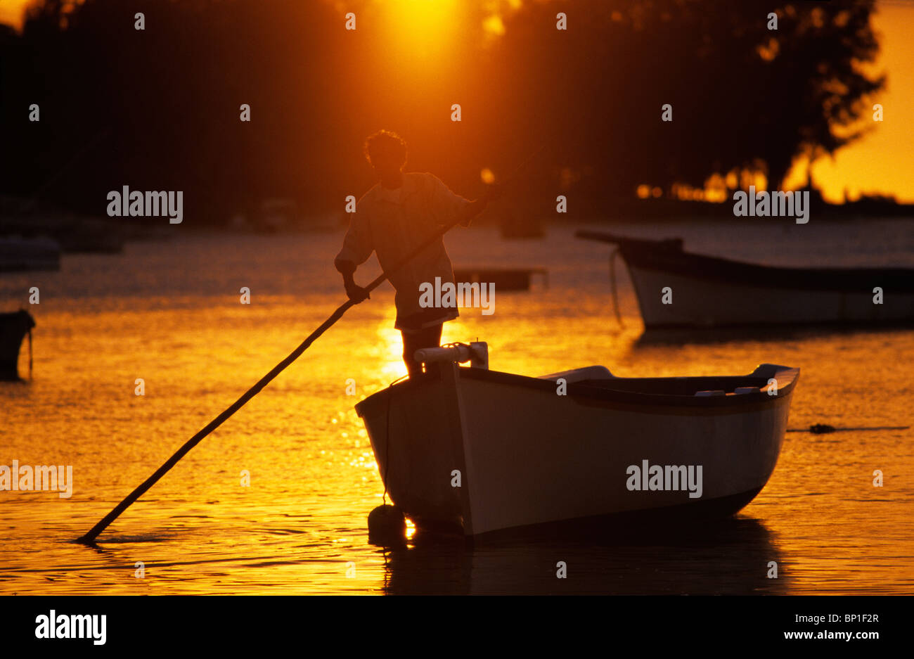 Lokale Fischer mit seinem Boot bei Sonnenuntergang. Insel Cape Malheureux, Mauritius, Indischer Ozean Stockfoto