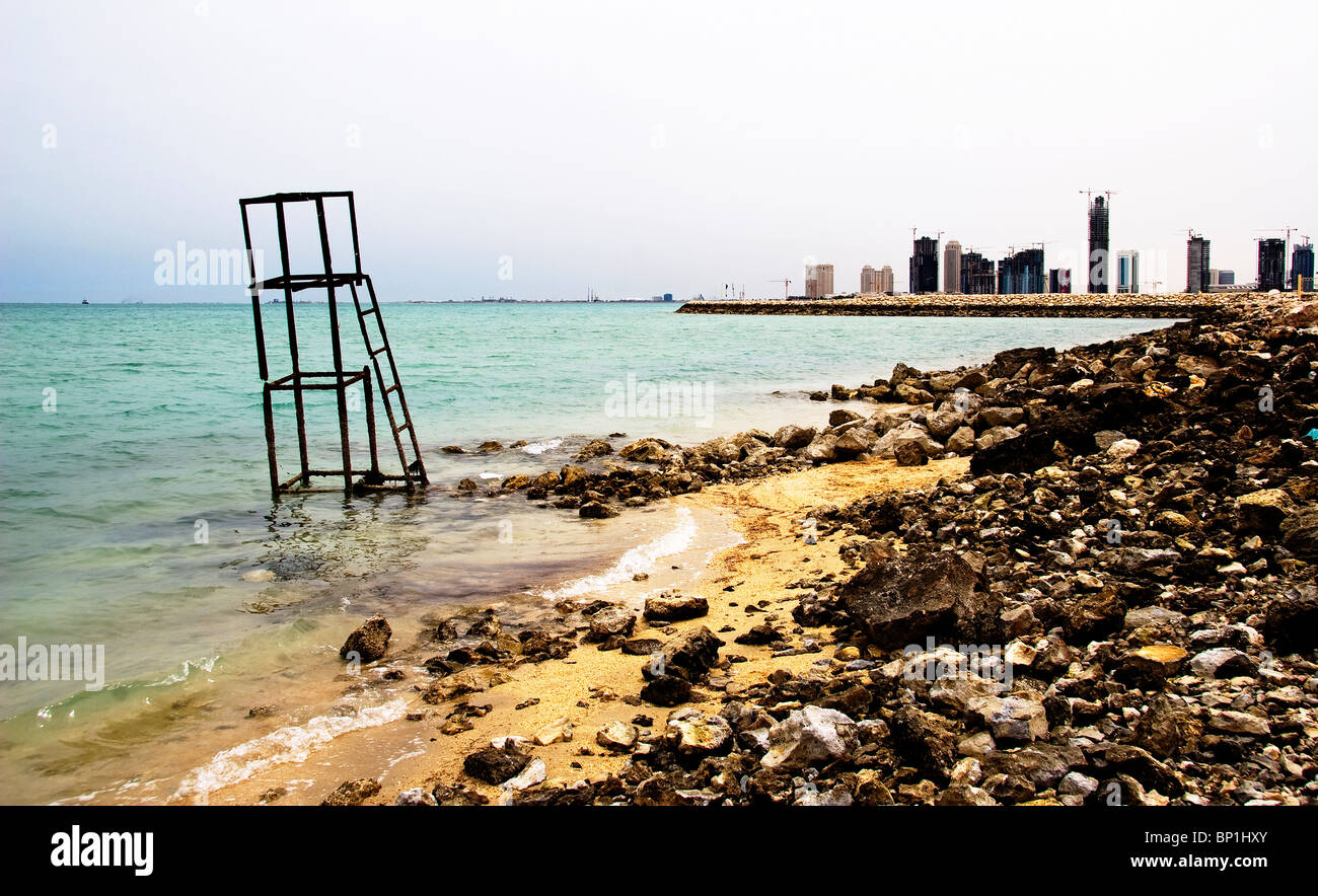 Blick über einen Naturstrand mit stillgelegten Rettungsschwimmer-Turm in Richtung urbar in Doha, Katar Stockfoto