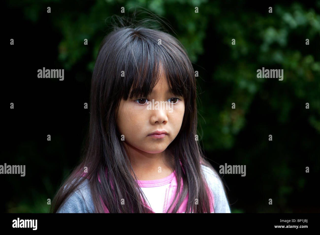 Ein halb-Thai-Mädchen steht sinnend auf einem Waldspaziergang Stockfoto