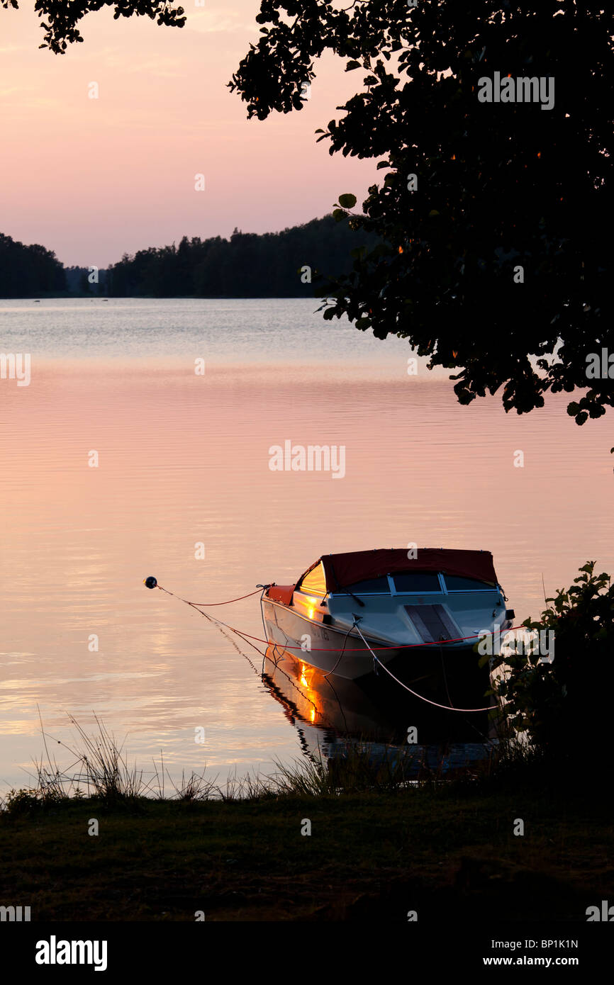 Mit dem Schnellboot am Strand eines Sees in orange sunset Stockfoto