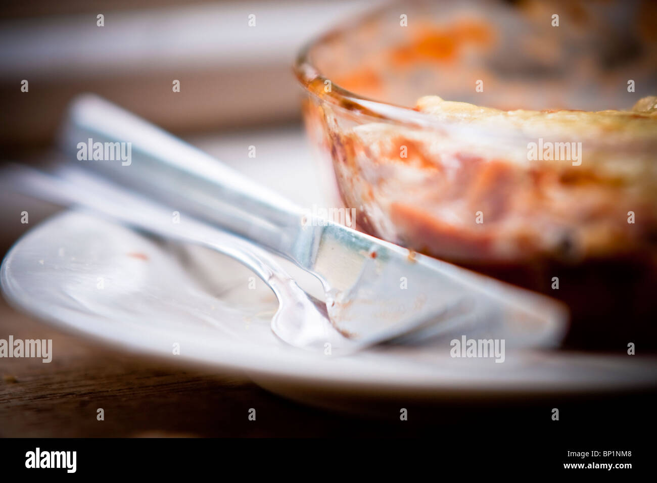 Ein Lebensmittel Produkt Schuss durch schönes weiches, natürliches Licht beleuchtet. Eine leere Gericht, die nach Hause hausgemachte Lasagne enthalten. Stockfoto