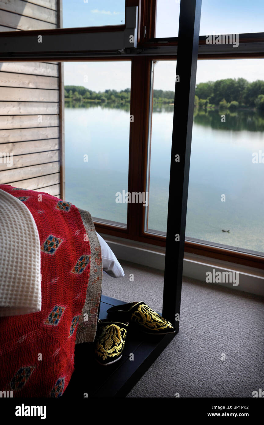 Schlafzimmer mit Blick auf einen See durch deckenhohe Fenster auf die "Zweitwohnung" Entwicklung - die Seen von Yoo in der Nähe von Cirences Stockfoto