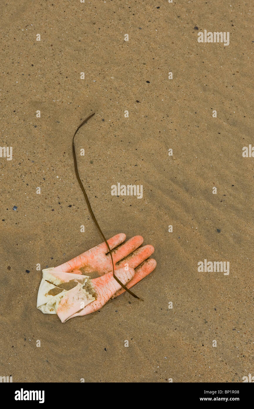 Ein Gummihandschuh auf Sand. Foto von Gordon Scammell Stockfoto