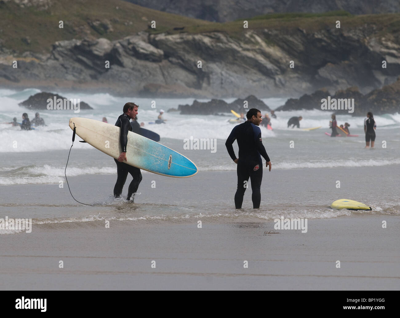 Surfer im Meer vor der Küste von Newquay, Cornwall. Stockfoto