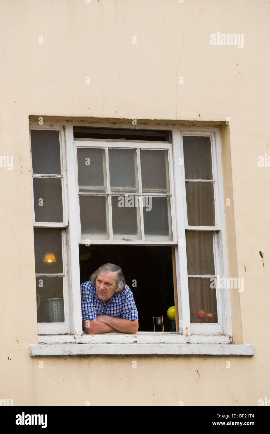 Mann aus offenen Flügel Fenster gerade Parade durch die Brecon Stadt während Brecon Jazz Festival 2010 Stockfoto
