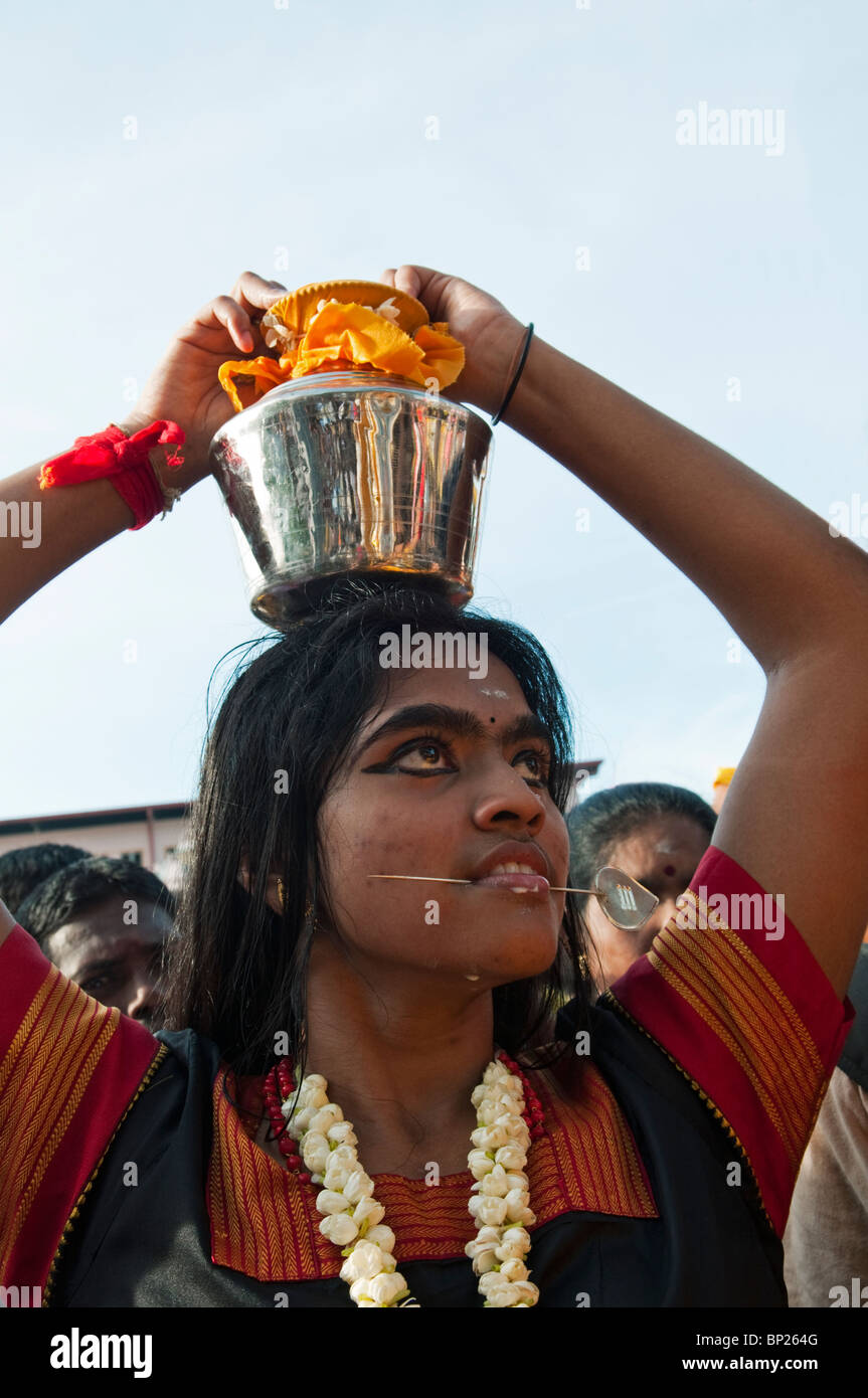 Hindu Anhänger mit genäht Wangen mit einem Lota mit Wasser während Thaipusam Festival in Batu Caves. Stockfoto