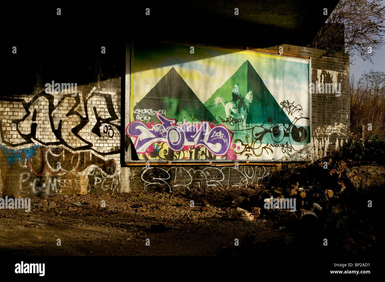 Graffiti auf eine Werbung für Zigaretten mit den ägyptischen Pyramiden, unter einer Brücke auf der North Circular Road, London, UK. Stockfoto