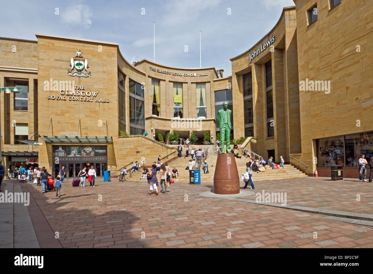 Das Denkmal des ehemaligen schottischen Ersten Ministers Donald Dewar am oberen Ende der Buchanan Street in Glasgow mit der Glasgow Royal Concert Hall dahinter. Stockfoto