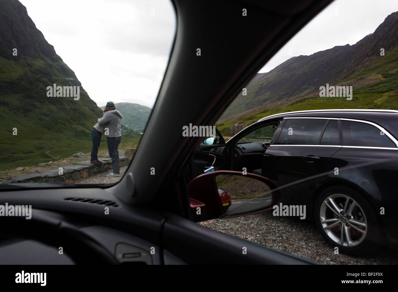 Paares spontanen Umarmung während gestoppt Autofahrt durch Glencoe, Schottland. Stockfoto