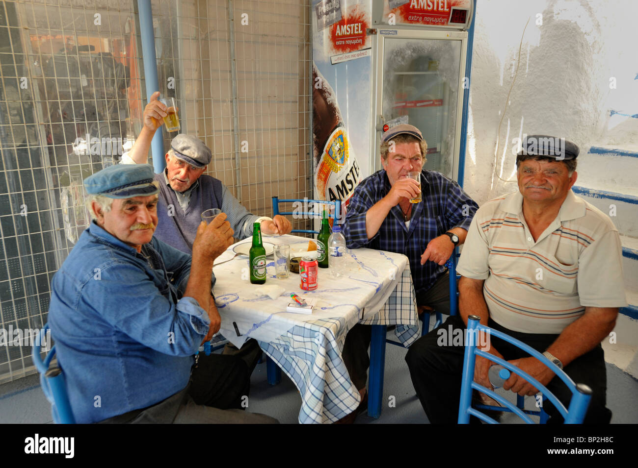 Vier griechische Männer, die den Esel arbeiten zu trainieren, dass Transporte die Touristen vom Hafen der Stadt Fira auf Santorin in Griechenland Stockfoto