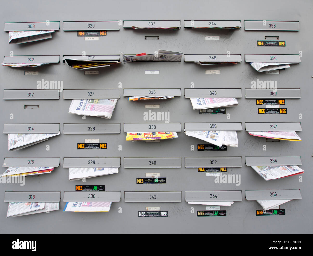 Mehrfamilienhaus Briefkästen voll von Junk-e-Mail in Amsterdam Niederlande Stockfoto