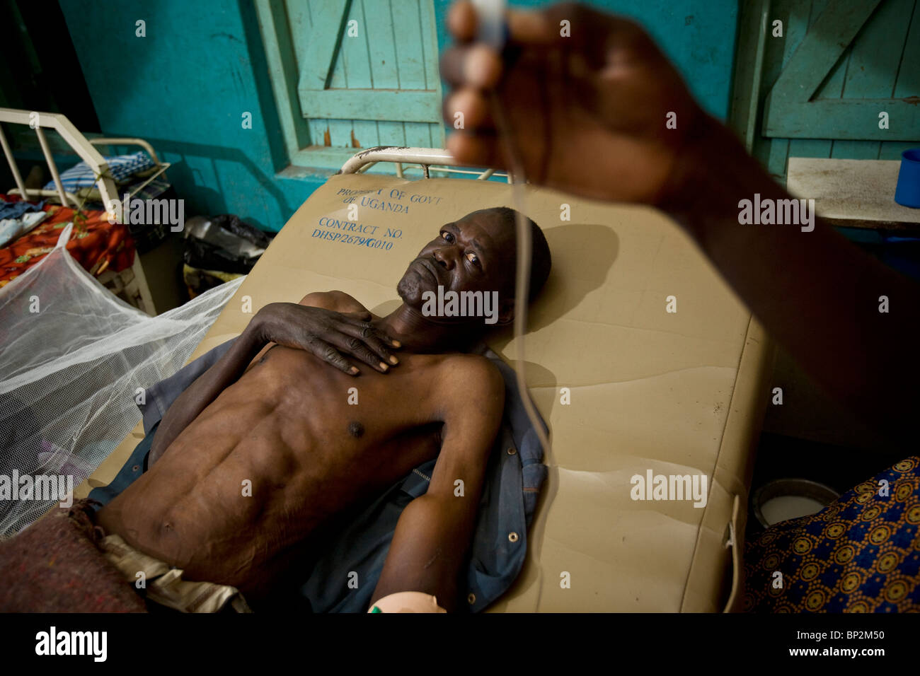 Ein ausgemergelten Mann liegt in einem Krankenhausbett in Amuria, NE Uganda, Ostafrika. Stockfoto