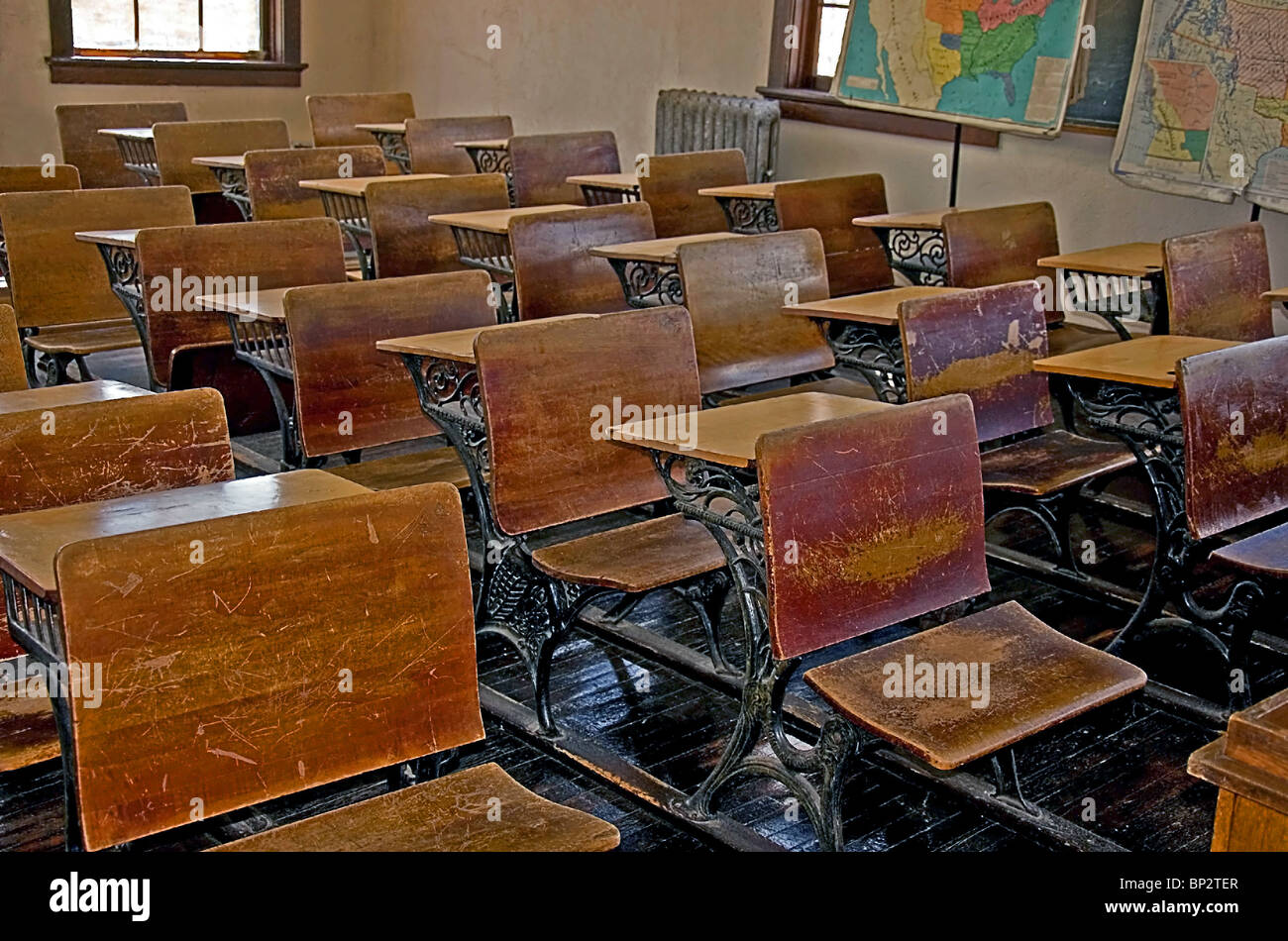 Vintage, Umdrehung der Jahrhundert alten Schulklasse mit hölzerne Schreibtische, Holzböden, alte Heizkörper und Vintage Karten. Stockfoto