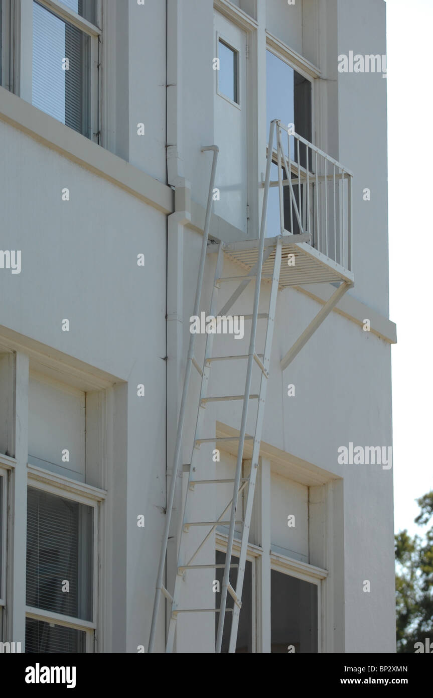 Notausgang Leiter und Treppe passend zur Seite eines sauberen weißen Gebäudes weiß lackiert. Stockfoto