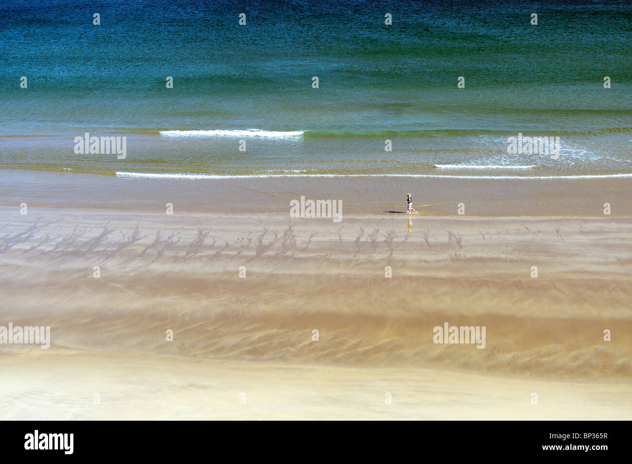 Frau Joggen laufen am einsamen Strand Ufer an den weißen Felsen zwischen Portrush und Bushmills, Nordirland Stockfoto