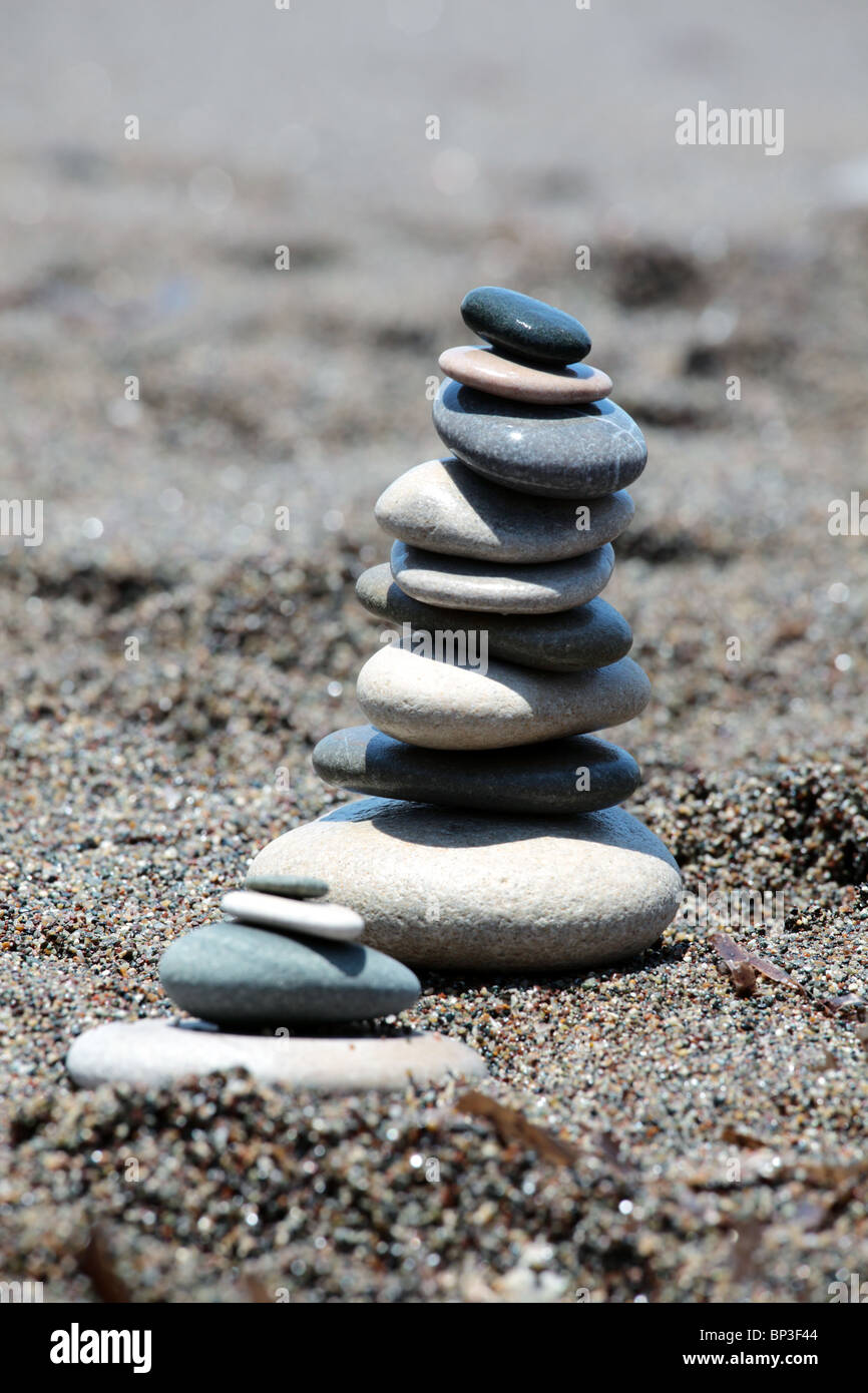Ausgewogene Steinen am Strandsand. Vertikale Zusammensetzung. Flachen DOF. Stockfoto