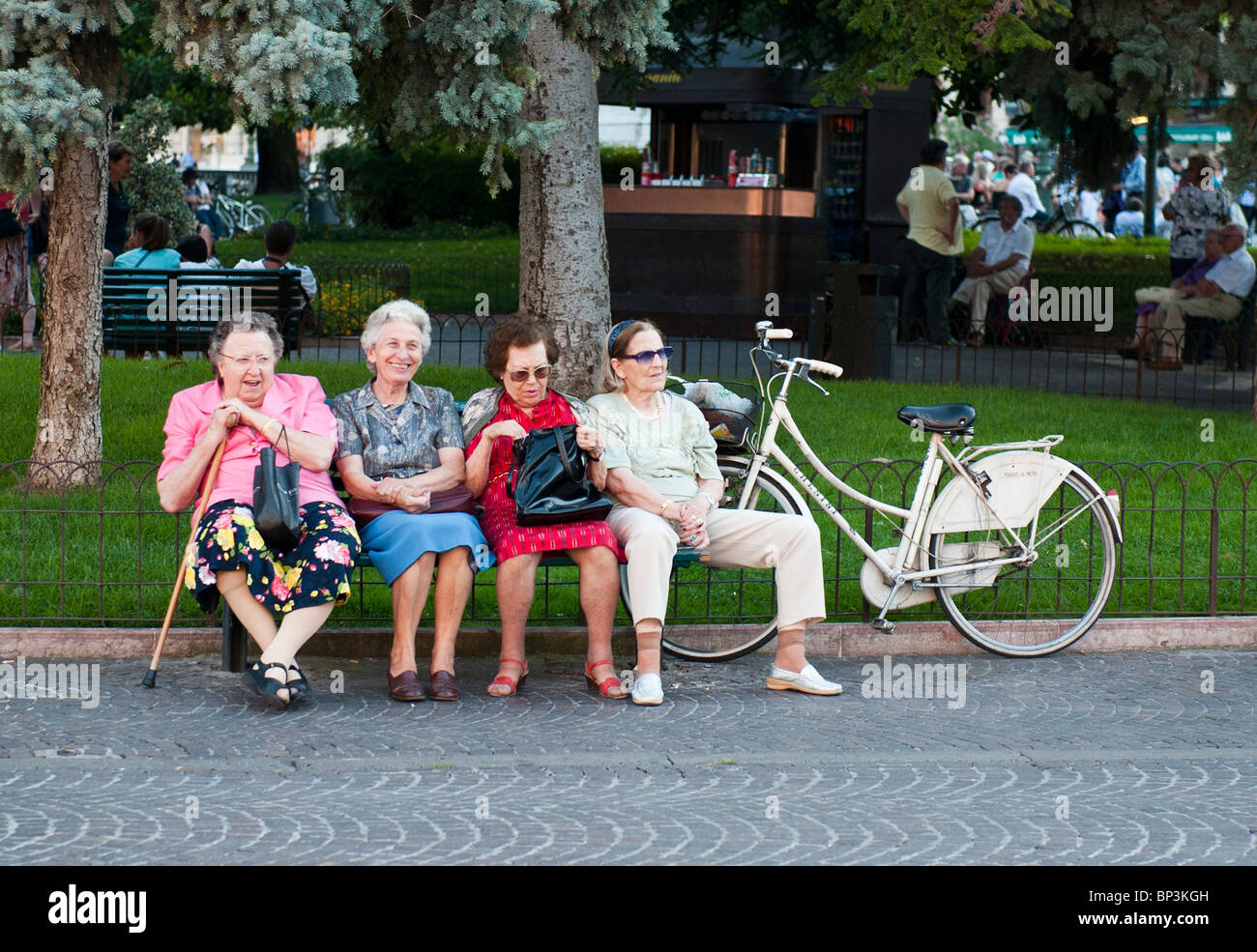 Vier ältere Frauen sitzen auf einer Bank in einem park Stockfoto