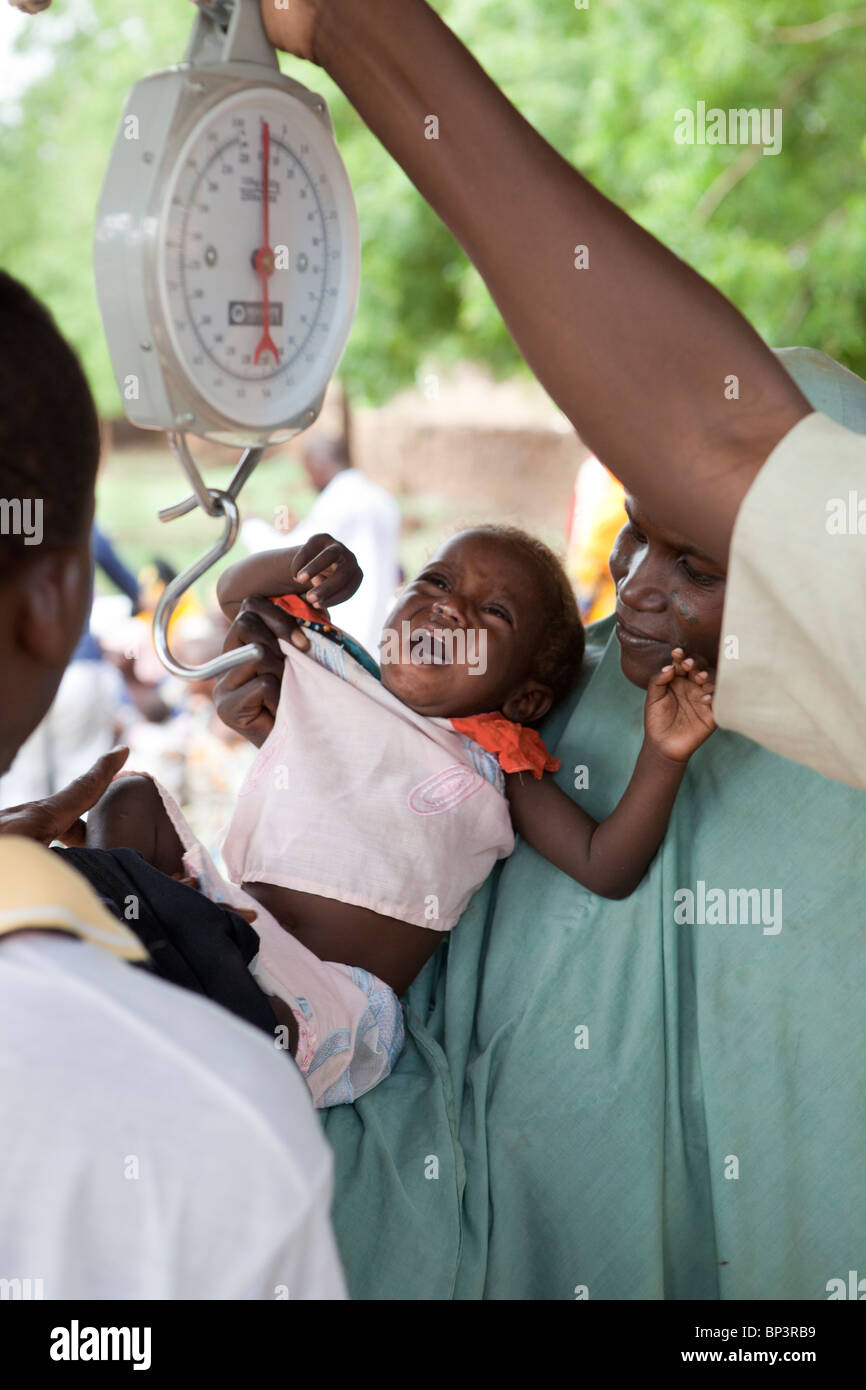 GUIDAN IDER Dorf, Niger: Mariam Aboubabcar, 36, bringt ihr Untergewicht Kind Rabiatou Aboubabcar 14 Monaten gewogen werden Stockfoto