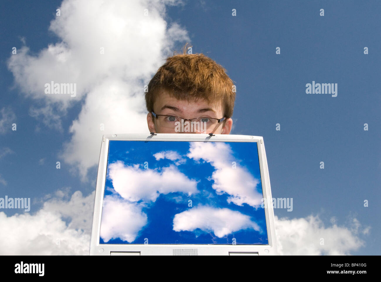 Teenager mit Laptop-Computer mit Wolke Bilder für Cloud-computing mit Wolken im Hintergrund Stockfoto