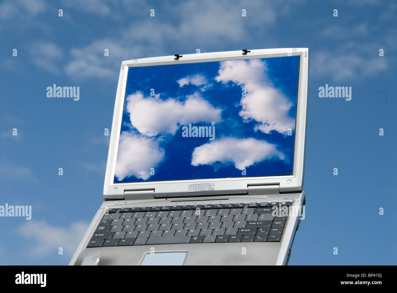 Laptop-Computer mit Wolke Bilder und Wolken im Hintergrund repräsentiert cloud-computing Stockfoto