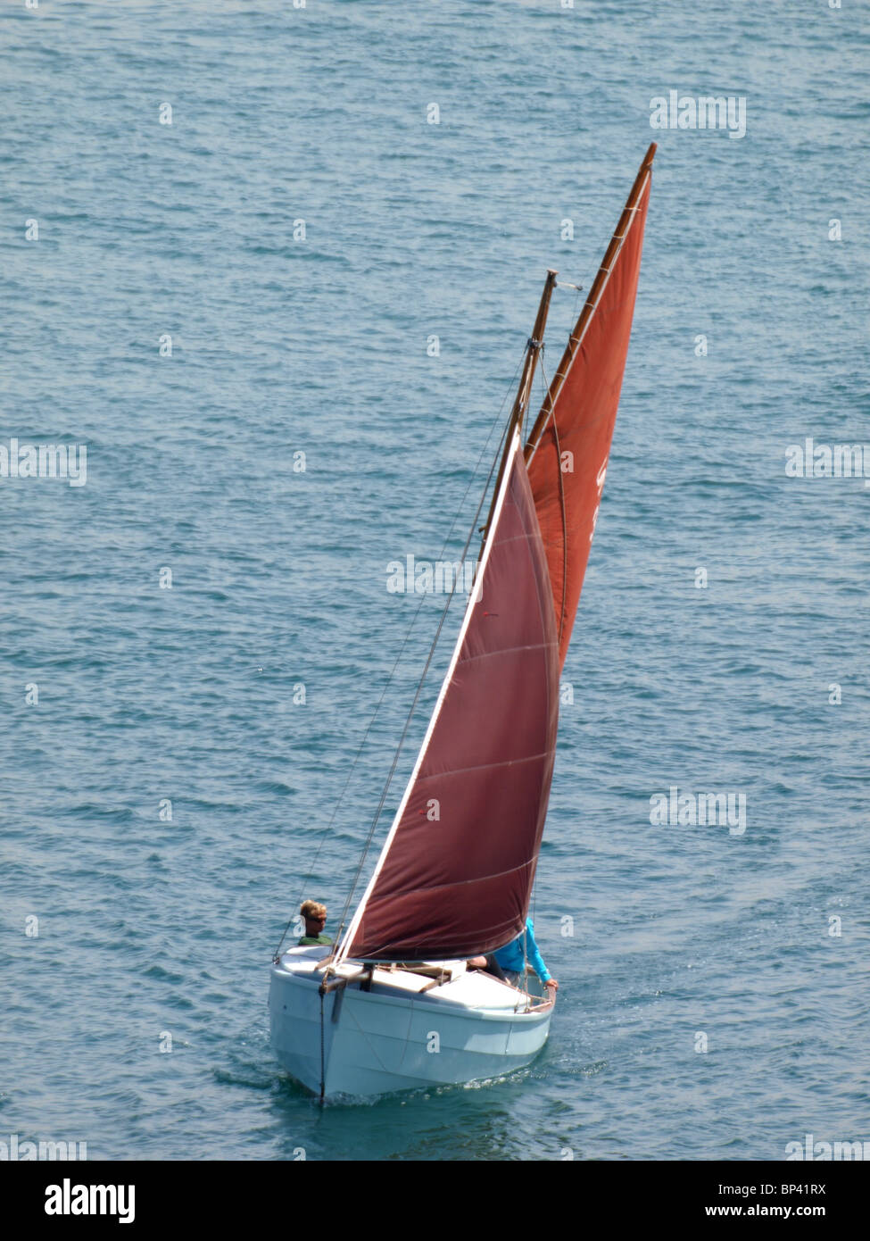 Segelboot mit roten Segeln, Cornwall, UK Stockfoto