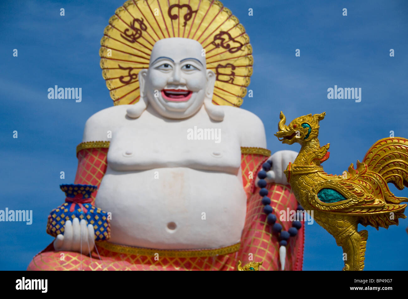 Thailand Ko Samui. Wat Plai Laem aka Plai Laem Tempel. Goldener Hahn-Statue vor Big happy Buddha of Prosperity Tempel. Stockfoto