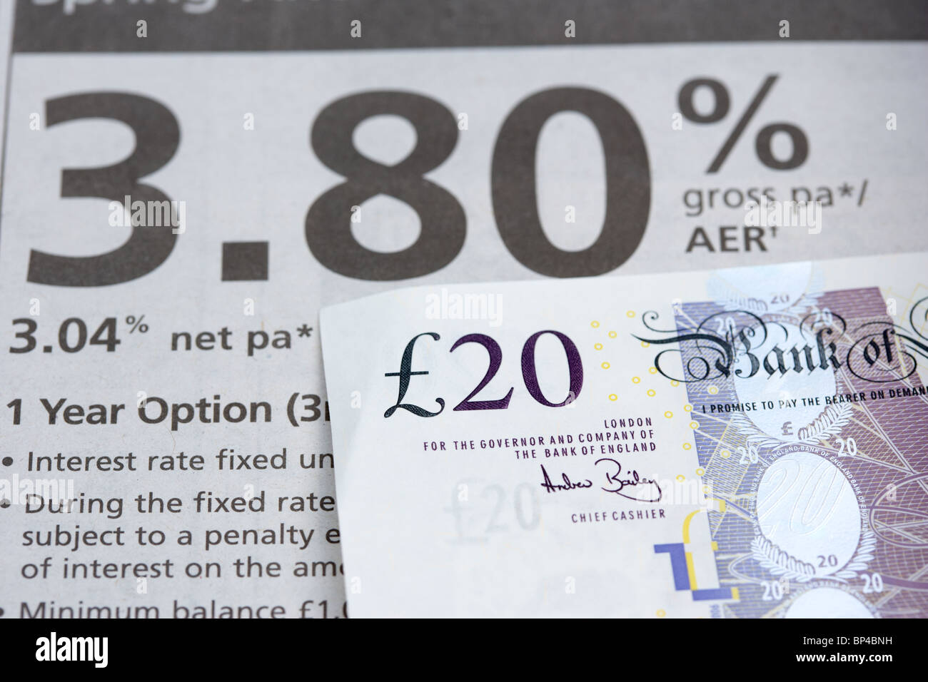 20-Pfund-Note neben einer Bank Darlehen Anzeige in einer Zeitung Stockfoto