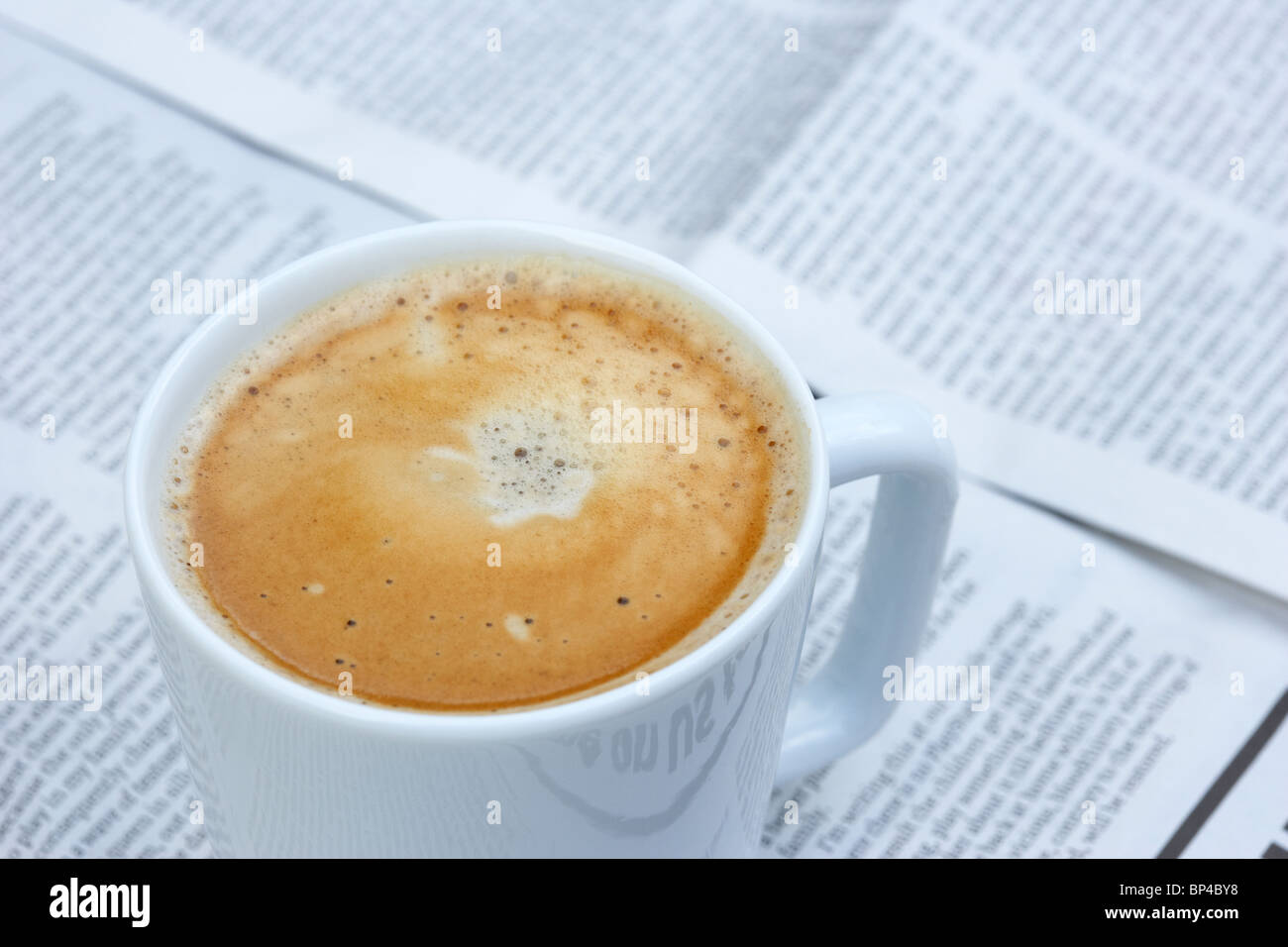 Tasse Kaffee sitzen auf einer Kopie einer Zeitung im Vereinigten Königreich Stockfoto