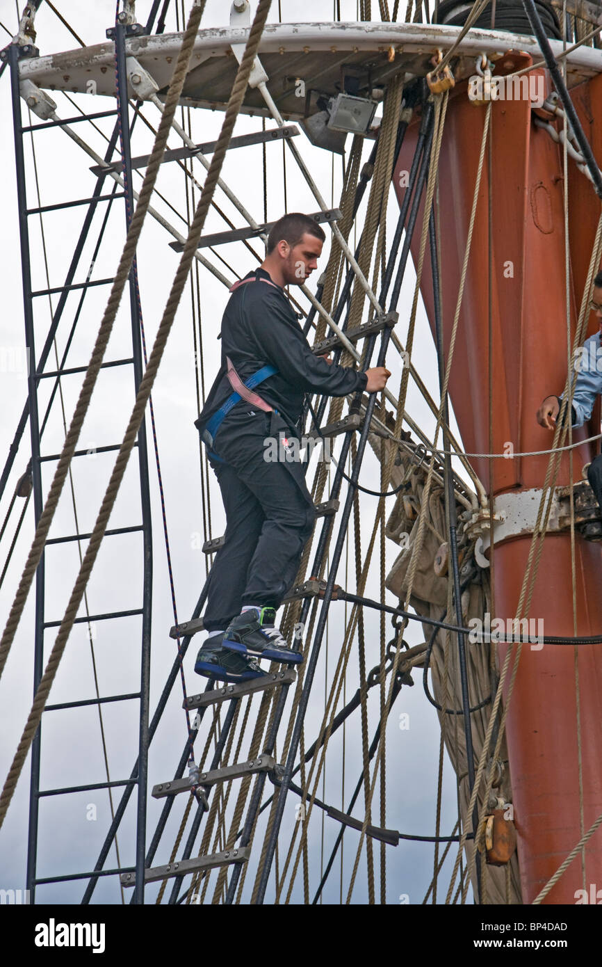 Besatzungsmitglied auf einem Quadrat manipuliert Segeln Schiff arbeiten hoch in der Takelage. Stockfoto