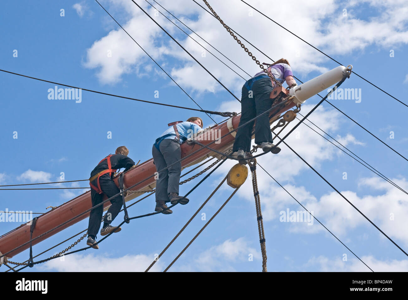 Mitglieder der Besatzung eines Quadrats manipuliert Segelschiff arbeitet an der mittleren Hof (Spar) von einem der Masten. Stockfoto