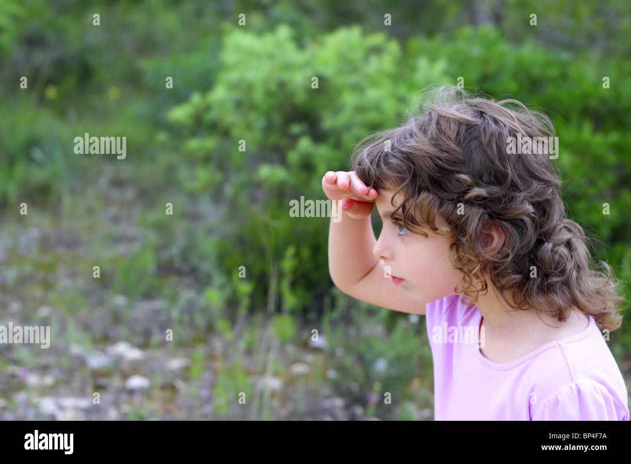 Explorer kleine Mädchen Waldpark Suche Hand in Stirn Stockfoto