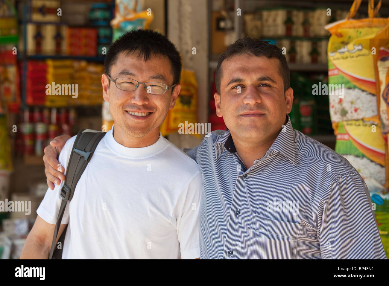 Koreanische amerikanische Touristin posiert mit einem Händler in den Basar, Dohuk, Kurdistan, Irak Stockfoto