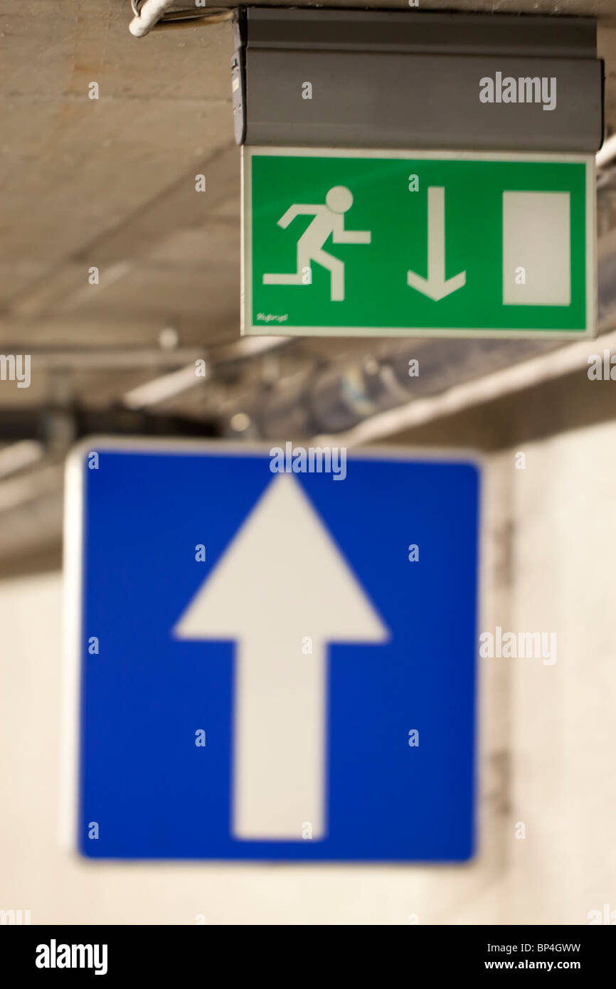 Blaues Schild mit einem weißen Pfeil nach oben und ein Notausgangsschild mit Pfeil nach unten Blaues Schild mit einem weißen Pfeil nach oben und ein Notausgangsschild mit Pfeil nach unten