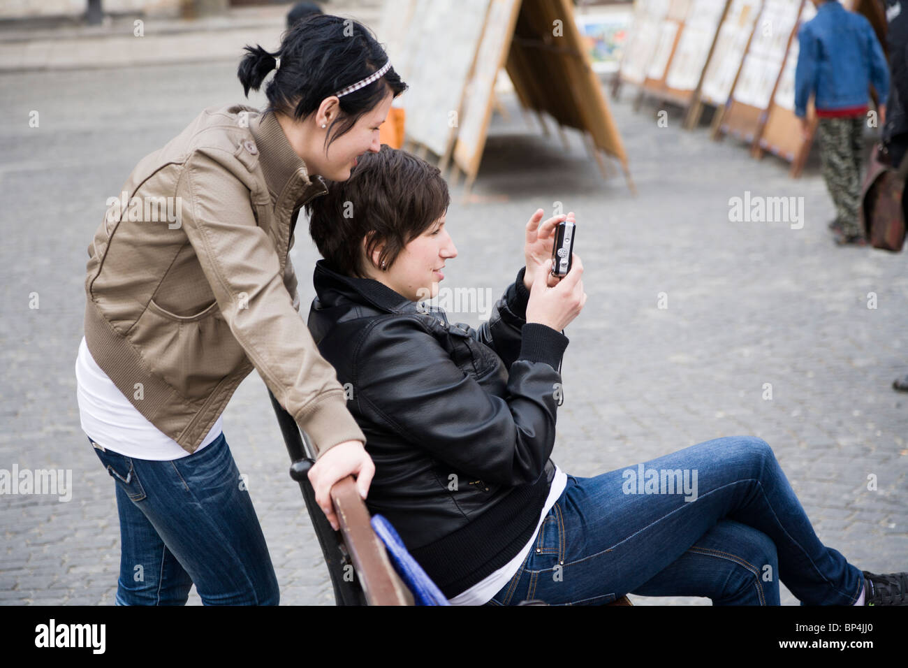 Zwei Mädchen betrachten von Fotos auf eine Kamera. Old Town Market Place, Warschau Polen. Stockfoto