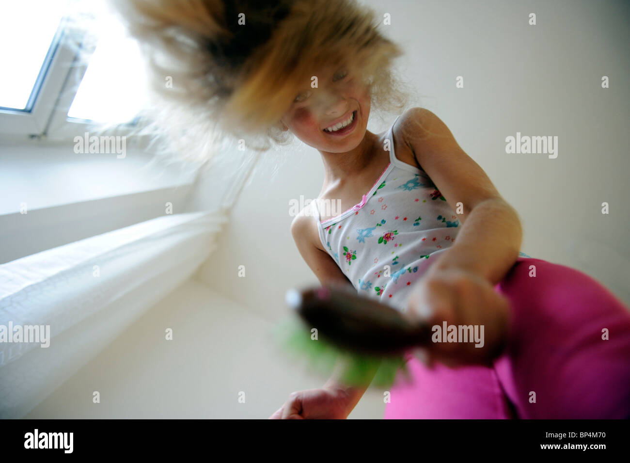 Mädchen von acht Jahren ihre Haare zu kämmen. Stockfoto